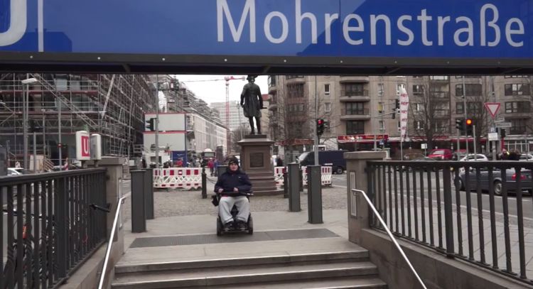 Rollstuhlfahrer vor U-Bahn-Treppe