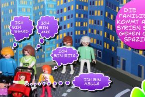Comic-Ausschnitt: Eine syrische Familie in einer fremden Stadt. In der Sprechblase steht: "Die Familie kommt aus Syrien. Sie gehen gerne spazieren." Alle stellen sich vor. Die Eltern heißen Ani und Ahmad. Die Kinder Sali, Ani, Rita und Mella. Die Figuren sind Playmobil-, LEGO- und Duplo-Figuren. Die Farben sind bunt und fröhlich.