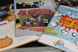 Comic Dein Heft mit aufgeklappten Beispielseiten