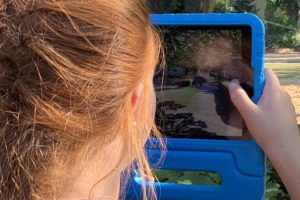 Mädchen fotografiert ihre Umgebung mit iPad