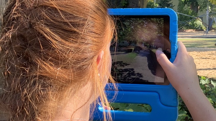 Mädchen fotografiert ihre Umgebung mit iPad