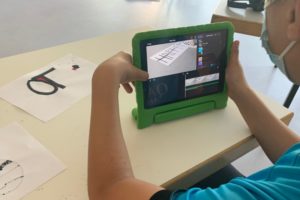 Mini-Roboter ozobots fahren auf Papier entlang der Schrift Happy Ostern und werden dabei gefilmt