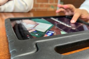 Nahaufnahme von einer Hand, die auf einem Tablet ein Video bearbeitet