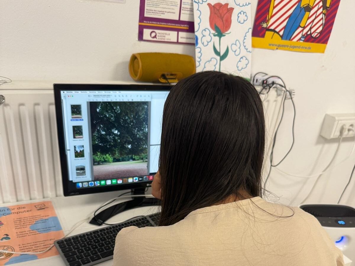 Ein Mädchen sitzt vor einem Computer und bearbeitet ihr Foto.